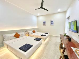 a living room with two beds and a ceiling fan at SkyVilla BKK - Pool & Chill - Laundry included in Phnom Penh