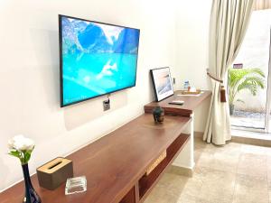 a living room with a flat screen tv on a wall at SkyVilla BKK - Pool & Chill - Laundry included in Phnom Penh
