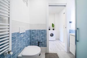 a bathroom with a toilet and blue tiles at Desenzano - 2' to Station & Lake - Pool, Wifi, AC in Desenzano del Garda +21 photos