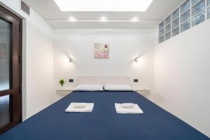 a room with a large blue table with towels on it at Desenzano - 2' to Station & Lake - Pool, Wifi, AC in Desenzano del Garda