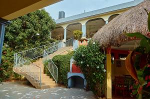 a building with stairs and plants in front of it at Chez Sabine in Abomey