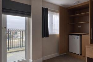 a kitchen with a large window and a refrigerator at Best Western Northfields Ealing Hotel -Northfield station Elizabeth line in London