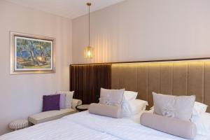 a hotel room with a bed and two chairs at Heritage Hotel Park Hvar in Hvar