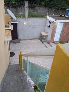 an outside view of a patio with a table and a window at J U N Q U E I R A i in Mangaratiba