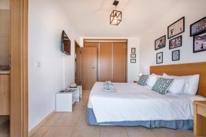 a bedroom with a large white bed with blue pillows at Casa Louro in Cabanas de Tavira +17 photos