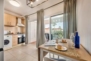 a kitchen with a table and a dining room at Casa Louro in Cabanas de Tavira
