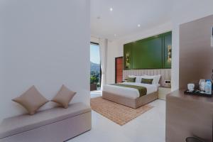 a bedroom with a bed and a couch at Orbit88 Hotel by AMR in Kandy