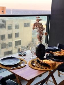 a table with plates and glasses and a vase at Art studio DA in Salvador