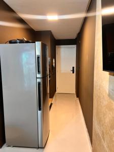 a stainless steel refrigerator in a room with a hallway at Art studio DA in Salvador