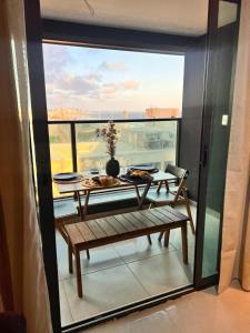 a table and bench on a balcony with a view at Art studio DA in Salvador
