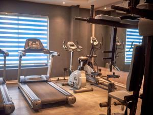 a gym with several exercise bikes and a treadmill at Tripod By Pedestal Hotel in Owerri