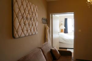 a living room with a couch and a bedroom at B&B Oesterhoeve in Ostend