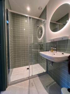 a bathroom with a glass shower and a sink at B&B en theetuin Loodiep in Zwinderen +6 photos
