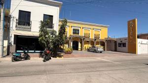 a motorcycle parked in front of a yellow and white building at Hotel La Cazona Boutique in La Barca