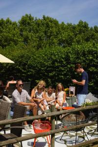 a group of people sitting at a picnic table at Hoeve de Binnenplaets - Appartementen - Glamping - Familieverblijf in Schimmert +31 photos