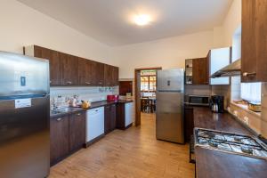 a kitchen with wooden cabinets and stainless steel appliances at Pensiunea Casa Brancovenilor in Sâmbăta de Sus