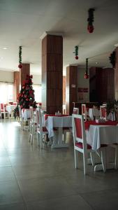 a dining room with a christmas tree and tables and chairs at Hotel do Papai Noel in Penedo