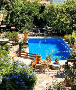 a swimming pool in a garden with a bench and flowers at Casa Jazmin in Órgiva