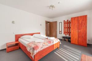 a bedroom with a large bed with a wooden headboard at Pensiunea Casa Brancovenilor in Sâmbăta de Sus