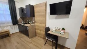 a room with a table and a kitchen with a television at BestFriends-Lenzing in Lenzing
