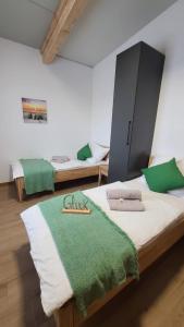 a room with two beds and a green blanket on a bed at BestFriends-Lenzing in Lenzing