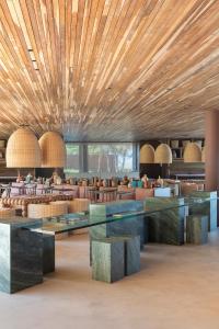 a restaurant with wooden ceilings and tables and chairs at Mana Cumbuco Hotel in Cumbuco