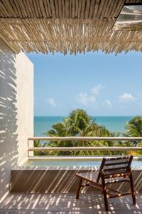 a bench sitting on a balcony with a view of the ocean at Mana Cumbuco Hotel in Cumbuco