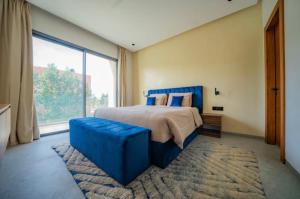 a bedroom with a blue bed and a large window at Villa Horizon in Marrakesh +59 photos
