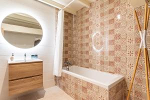 a bathroom with a tub and a sink and a mirror at Les Nuits du Pastelier in Teulat +28 photos
