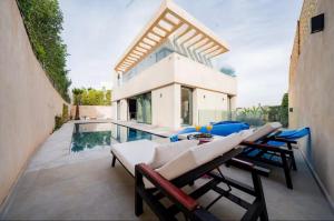 a house with a pool and some chairs and a table at Villa Horizon in Marrakesh