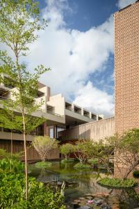 an office building with a pond in front of it at Mana Cumbuco Hotel in Cumbuco