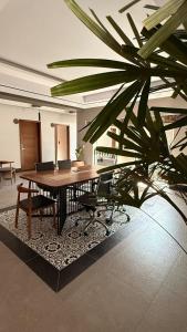 a table with chairs and a palm tree in a room at Hotel La Cazona Boutique in La Barca