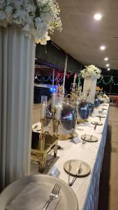 a long table with white plates and silverware on it at Furtado's Beach Resort in Benaulim