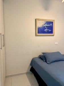 a bedroom with a bed and a painting on the wall at Pool house próximo ao centro in Matinhos +5 photos