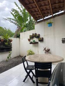 a patio with a table and two chairs and a fence at Pool house próximo ao centro in Matinhos