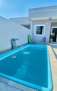 a swimming pool with a fountain in a house at Pool house próximo ao centro in Matinhos