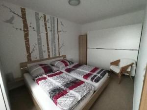 a bedroom with a bed with a blanket on it at Ferienwohnung Edelmann in Markersbach