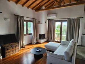 a living room with a couch and a tv at Paralies Resort in Skiathos