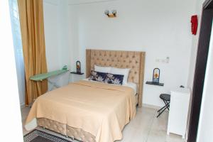 a bedroom with a large bed and a chair at Fola Home in Abidjan