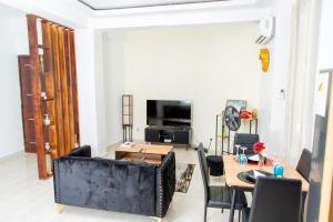 a living room with a table and a television at Fola Home in Abidjan