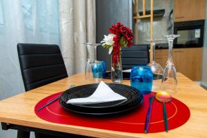 a table with a black plate on a red napkin at Fola Home in Abidjan