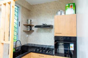 a kitchen with a black stove top oven next to a window at Fola Home in Abidjan +14 photos