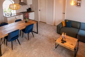 a living room with a table and a couch at Hoeve de Binnenplaets - Appartementen - Glamping - Familieverblijf in Schimmert