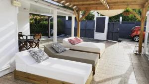 a patio with two white couches and a table at River Side in Sainte-Rose