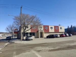 a parking lot with cars parked in front of a building at Minnedosa Inn in Minnedosa