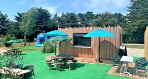 a small building with tables and chairs and umbrellas at Camping Saint-Gildas-de-Rhuys in Saint-Gildas-de-Rhuys +12 photos
