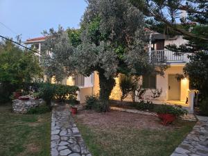 a house with a tree in the yard at Paralies Resort in Skiathos