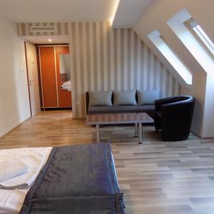 a living room with a couch and a chair at Fortuna Hotel in Miskolctapolca