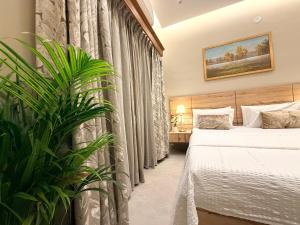 a hotel room with a bed and a plant at MILANO By The Beach Goa in Benaulim +50 photos