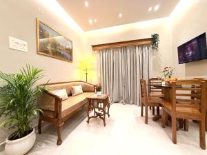 a living room with a couch and a piano at MILANO By The Beach Goa in Benaulim
